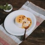Flan Dessert with Passion Fruit Sauce on a Plate, and Striped Tea Towel